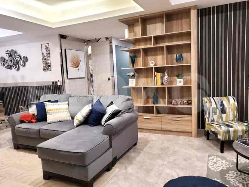 A modern living room featuring a gray sectional sofa, wooden shelving unit, and decorative accents.