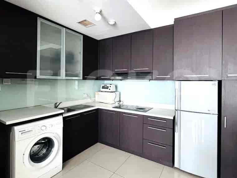 Modern kitchen with dark wooden cabinetry, a refrigerator, and a washing machine.