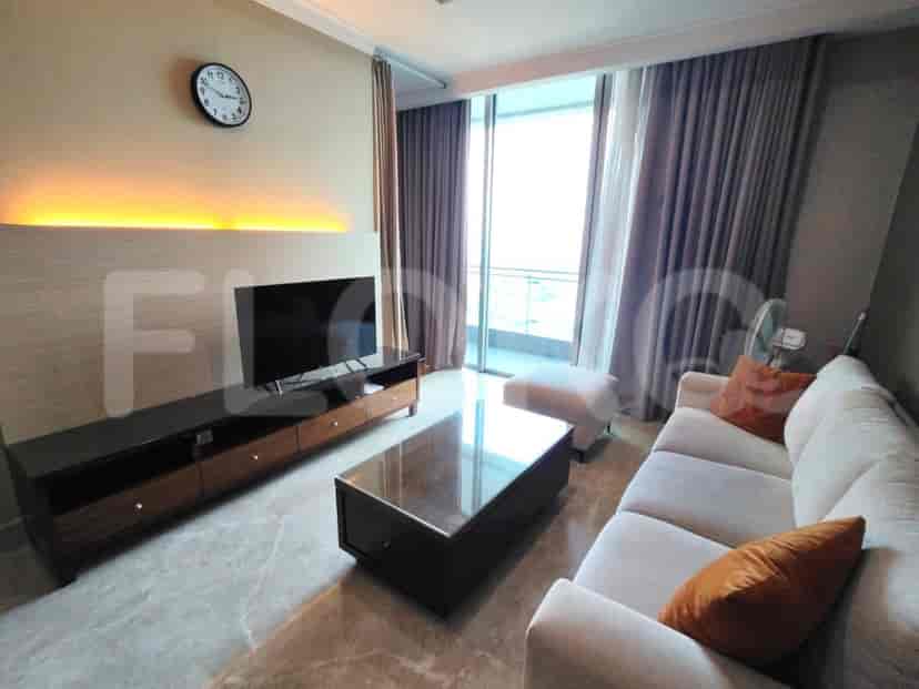 Modern living room featuring a dark wood TV stand, an L-shaped sofa, a glass coffee table, and large windows.