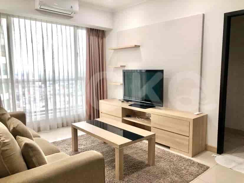 A modern living room with wooden furniture, a TV, and a seating area.