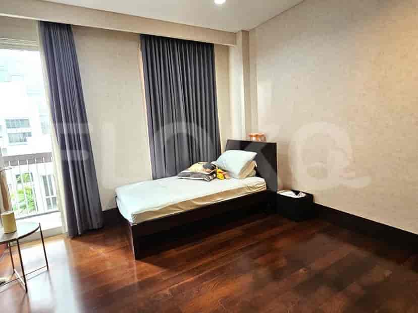 Guest bedroom with a single bed and wooden flooring.