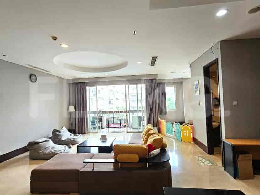 Spacious living room with a seating area, baby play area, and large windows.