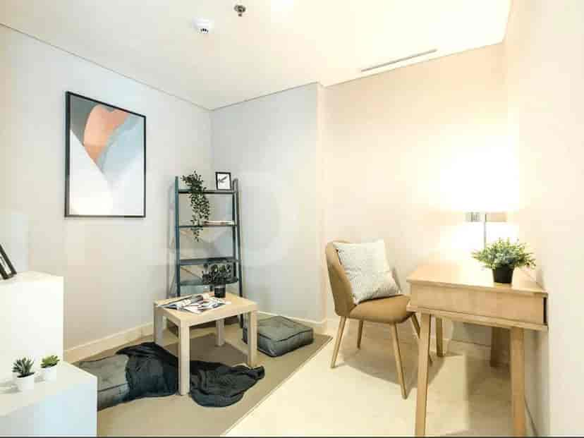 A room with a small desk, chair, and shelving unit.