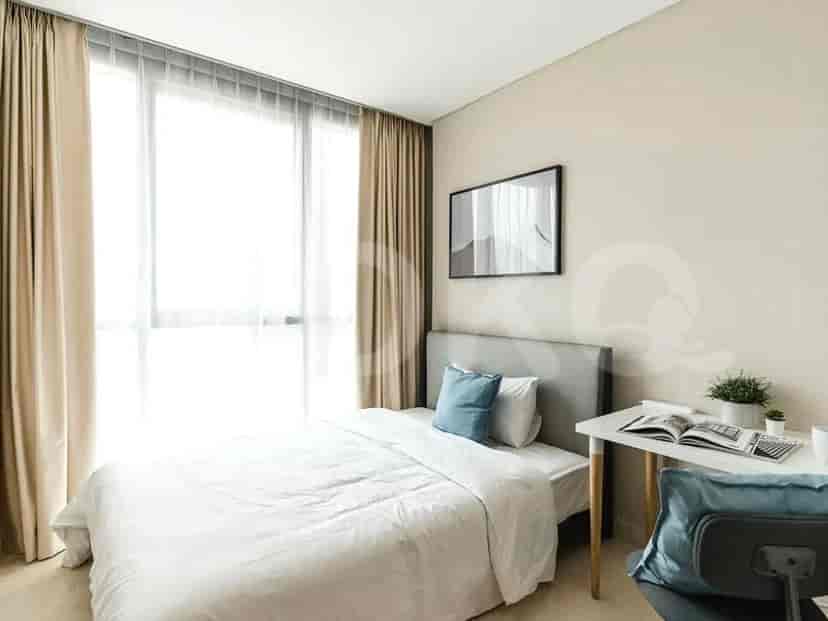 Bedroom with a bed, desk, and large window with sheer curtains.