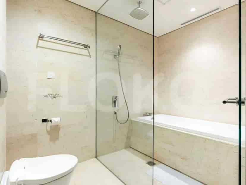 Bathroom with a bathtub, glass shower enclosure, and toilet.