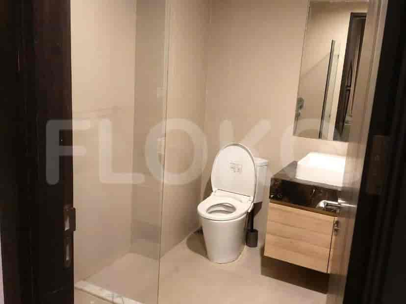 A modern bathroom featuring a toilet, sink, and glass-enclosed shower.