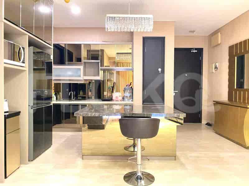 A modern kitchen with mirrored cabinets, a marble island, and a chandelier.