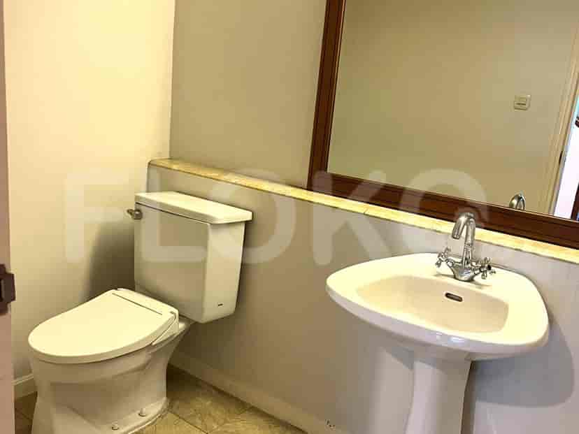 Bathroom with a toilet, sink, and mirror.