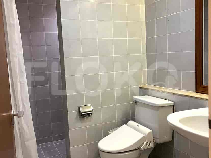 A small bathroom with a toilet, sink, and shower.
