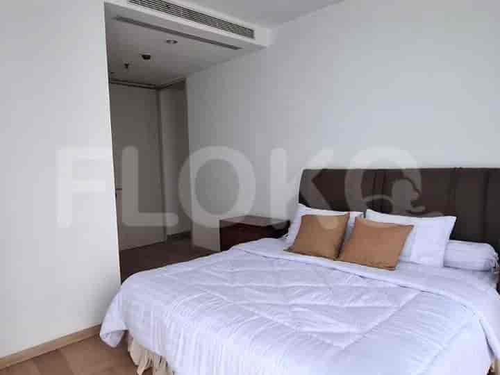 Kamar tidur dengan tempat tidur ganda, dekorasi bernuansa netral, dan lemari.