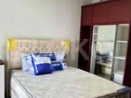 Kamar tidur yang cerah dengan tempat tidur ganda, lemari pakaian, dan jendela.