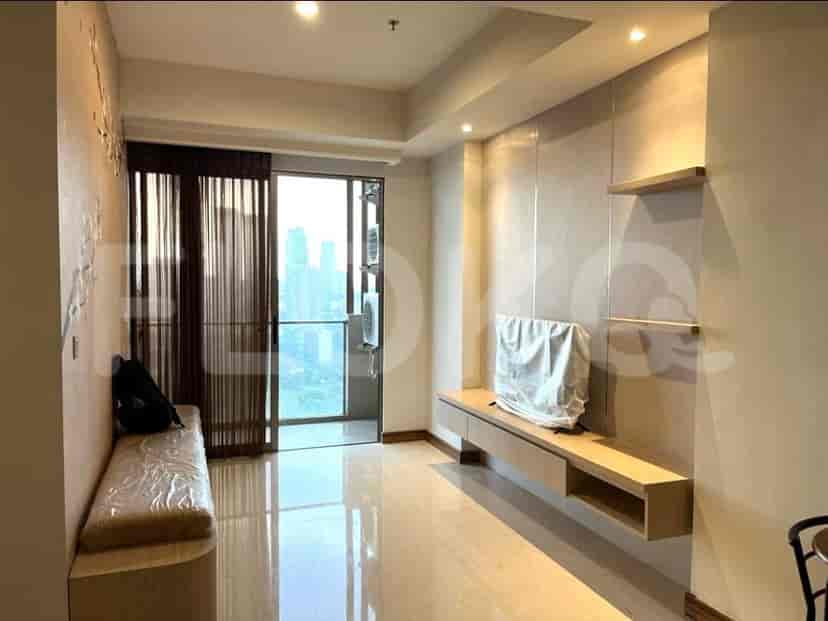 Ruang tamu dengan jendela setinggi langit-langit, sofa, dan lemari built-in.