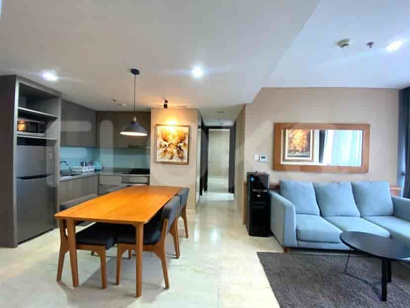 Open concept living space with a dining area, kitchen, and living room. Features a dining table, kitchen appliances, and a living area with a sofa.