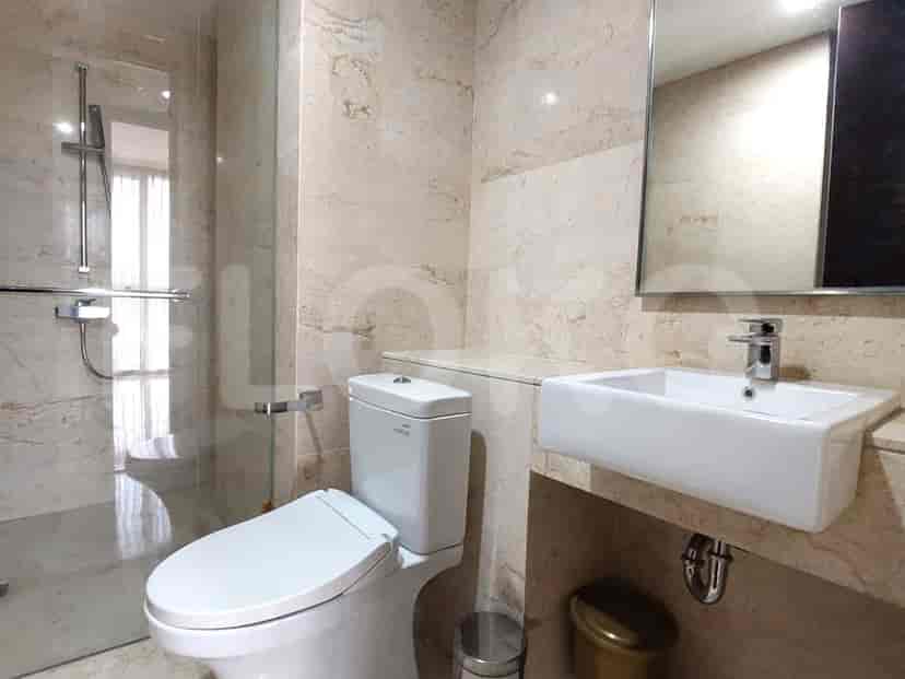 A luxurious bathroom with marble finishes, a modern sink, and a glass shower.