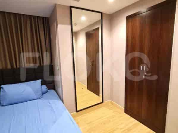 Kamar tidur dengan tempat tidur, cermin, dan lemari pakaian kayu.