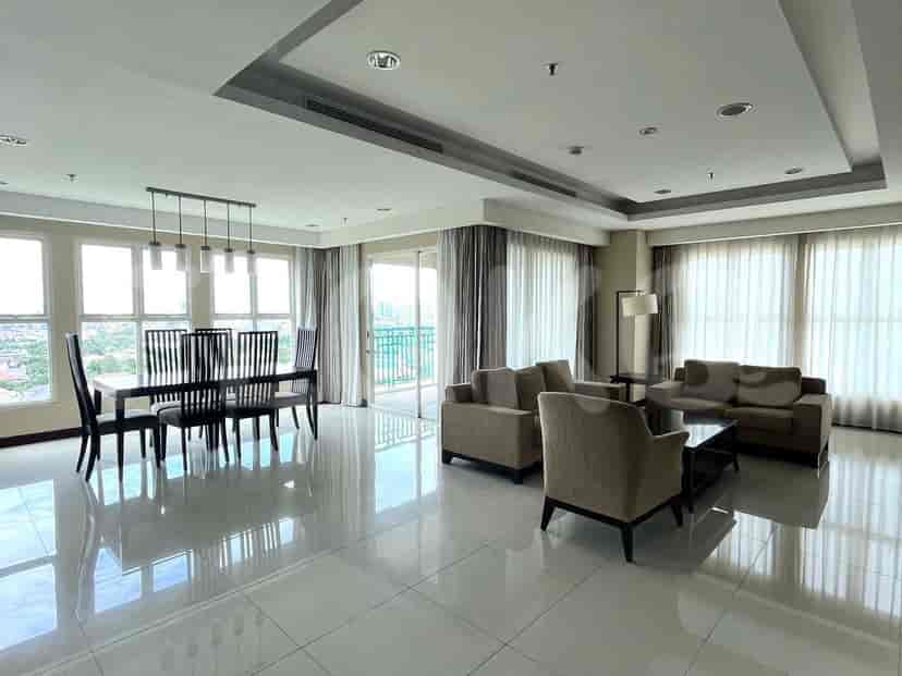 Spacious living and dining area with large windows, a dining table, and a seating area.