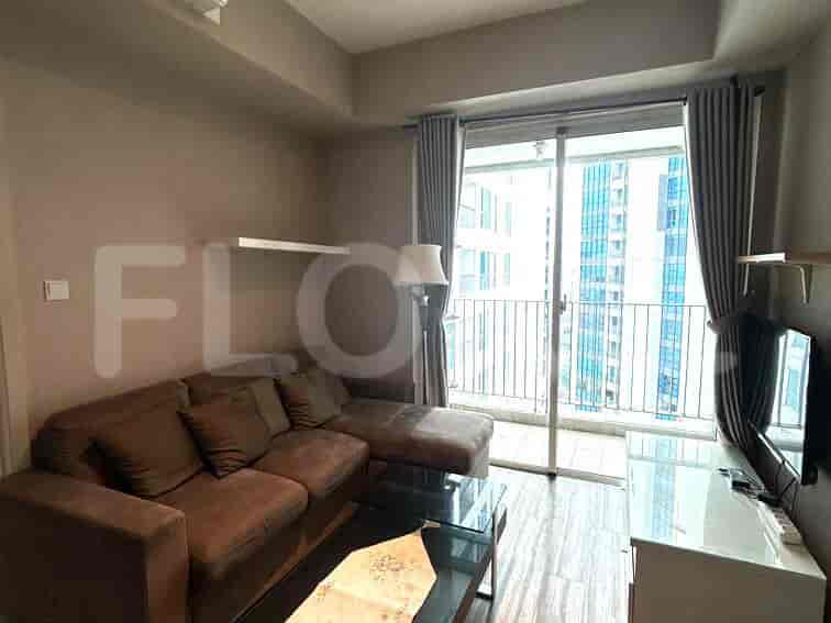 Living room with a brown L-shaped sofa, glass coffee table, and balcony access.