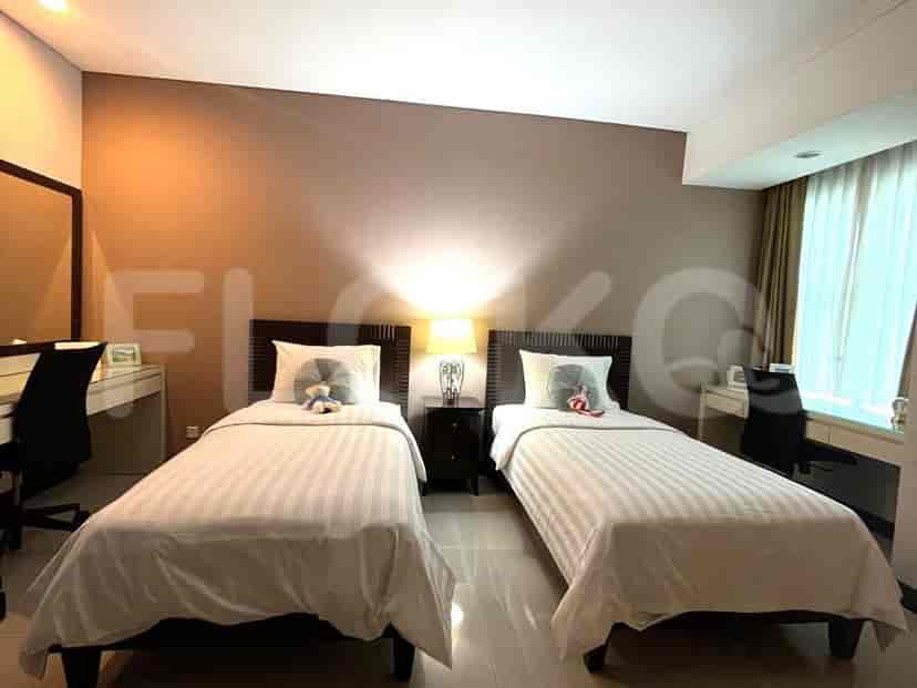 Bedroom with two single beds, bedside table, and study desks.