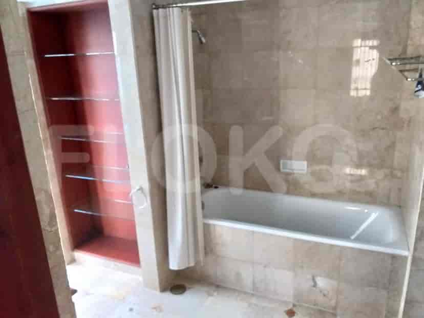 Bathroom with a bathtub and marble-like tiles.