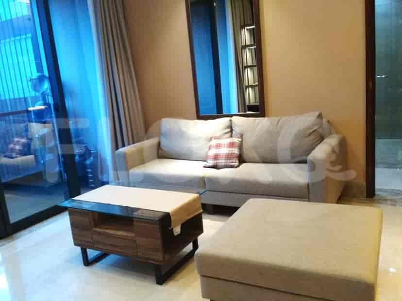 A living room with a grey sofa, coffee table, and ottoman.