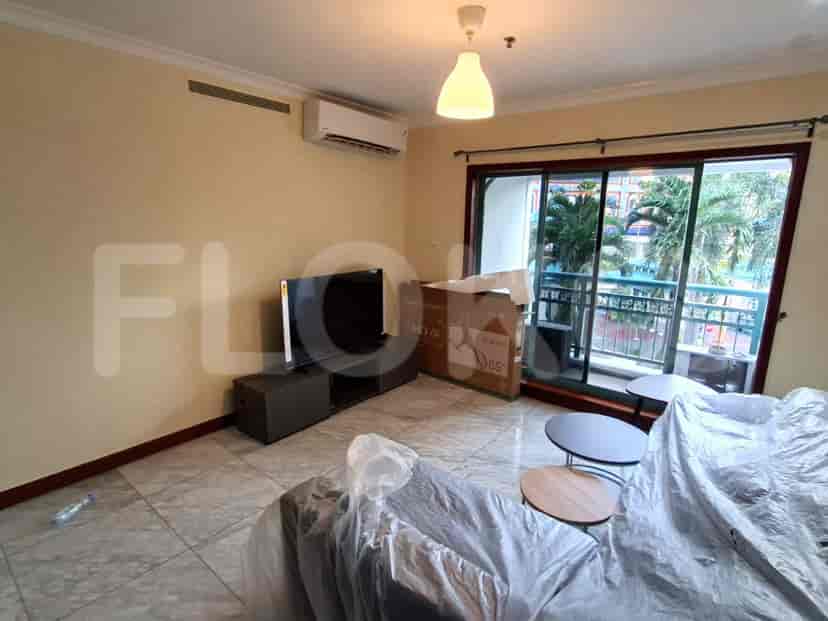 Living room with TV and balcony access.
