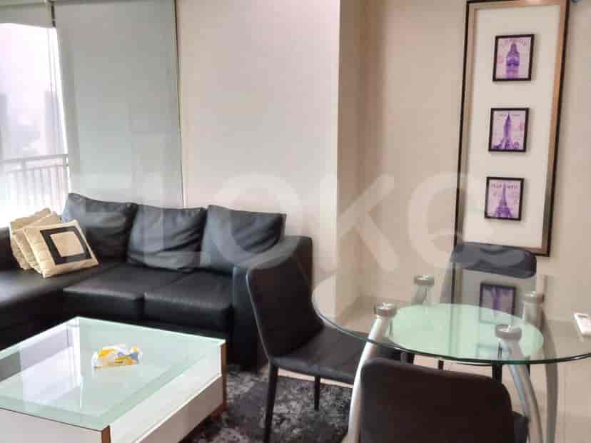 Living room with a black sofa, glass table, and dining set.