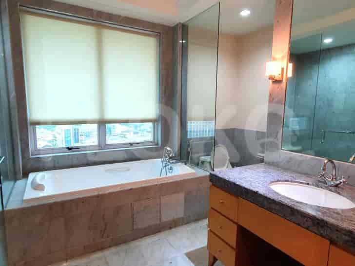 A luxurious bathroom with a bathtub, vanity, and a view.