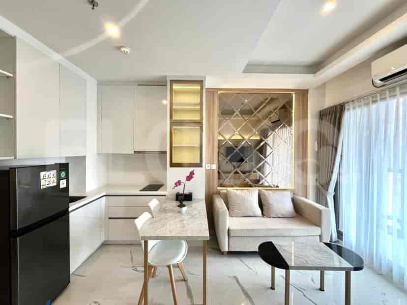 A modern kitchen and living area combination with white cabinetry, marble table, and a cream sofa.