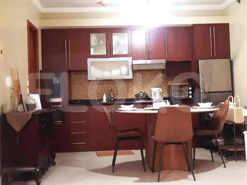 Modern kitchen with wooden cabinets, a round table, and a stainless steel refrigerator.