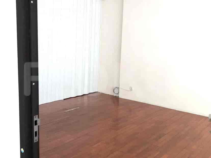 An empty room with wood flooring and a window.