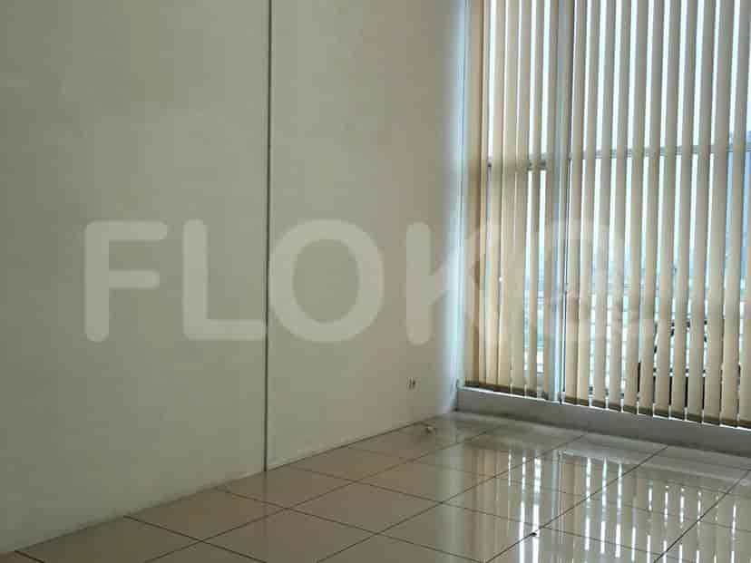 An empty room with tiled floors, a vertical blind, and plain walls.