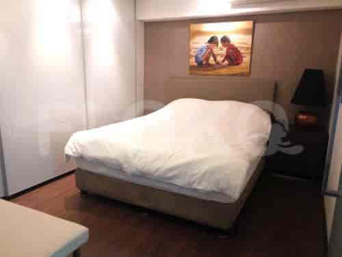 A modern bedroom with a large bed, painting, and a minimalist design.