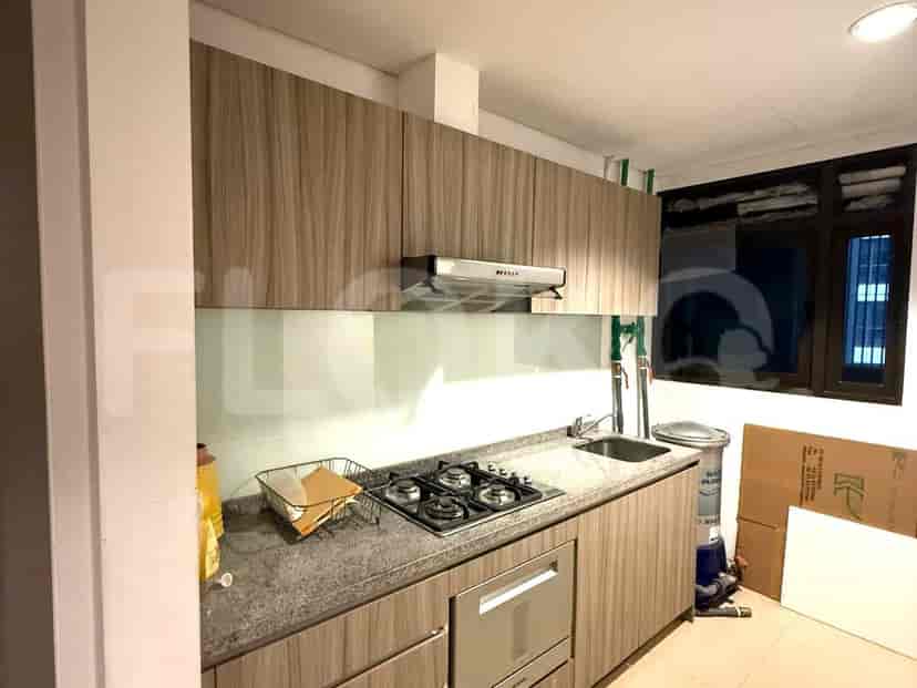 A modern kitchen with wooden cabinets, a gas stove, and a stainless steel sink.
