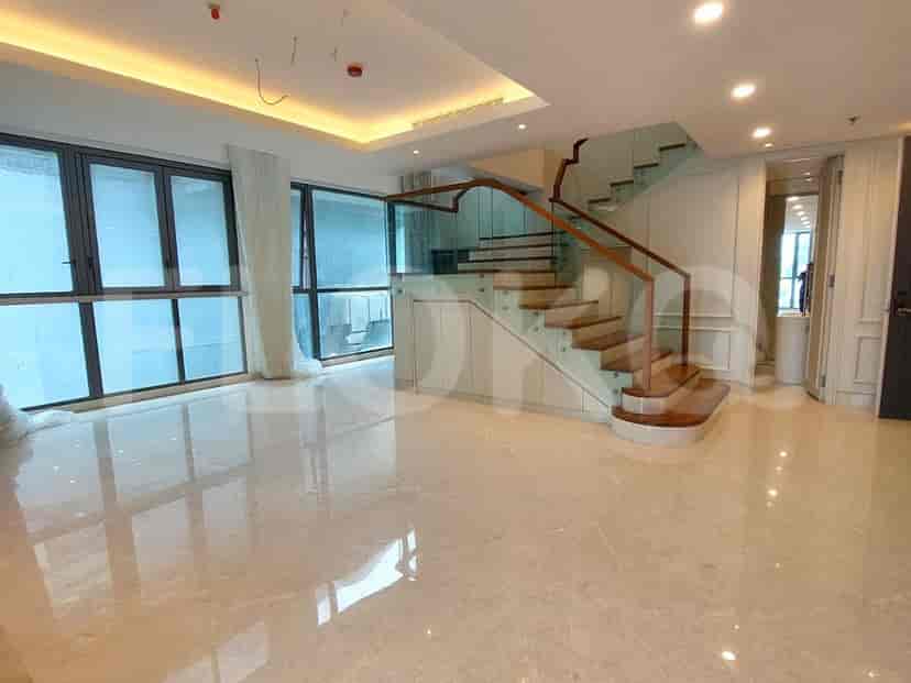 Spacious living room with marble flooring, a staircase, and large windows.