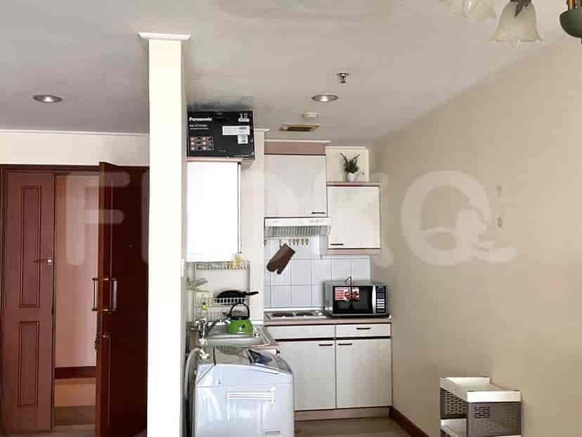 Compact kitchen featuring white cabinets, a stove, and a refrigerator.