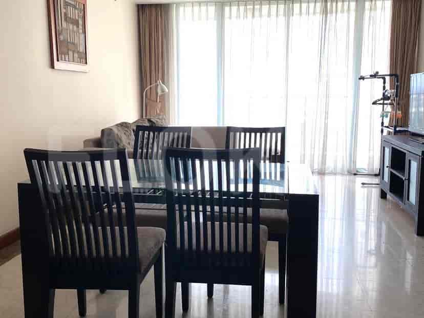 Elegant dining area with a glass-top dining table and matching chairs.