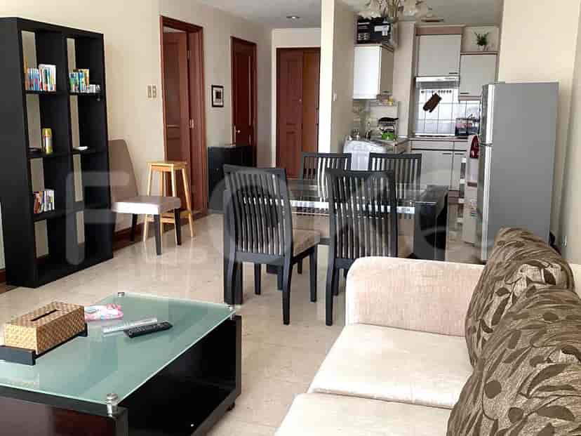 Spacious living room with dining area, featuring a sofa, glass coffee table, bookshelf, and dining table.