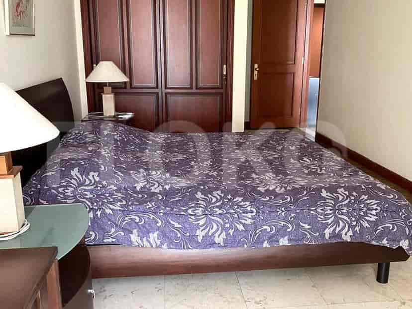 Cozy bedroom featuring a double bed with a patterned duvet and bedside lamps.