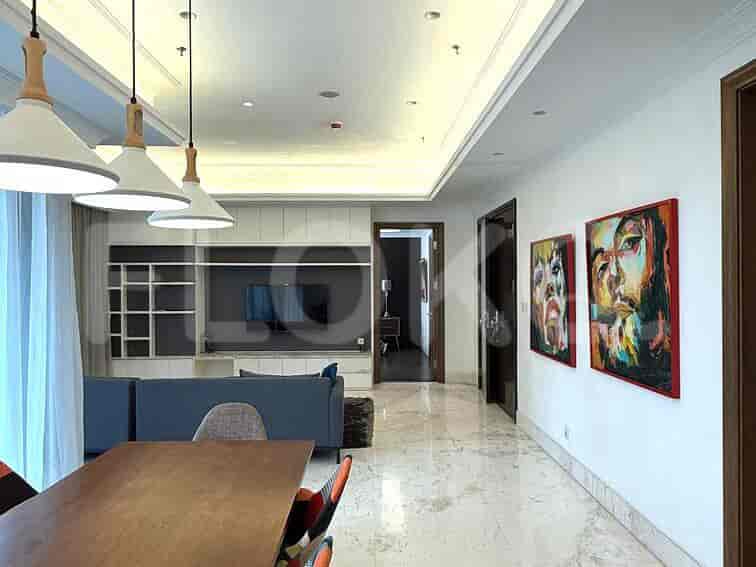 Ruang tamu dan area makan modern, dengan sofa, meja makan, dan karya seni.