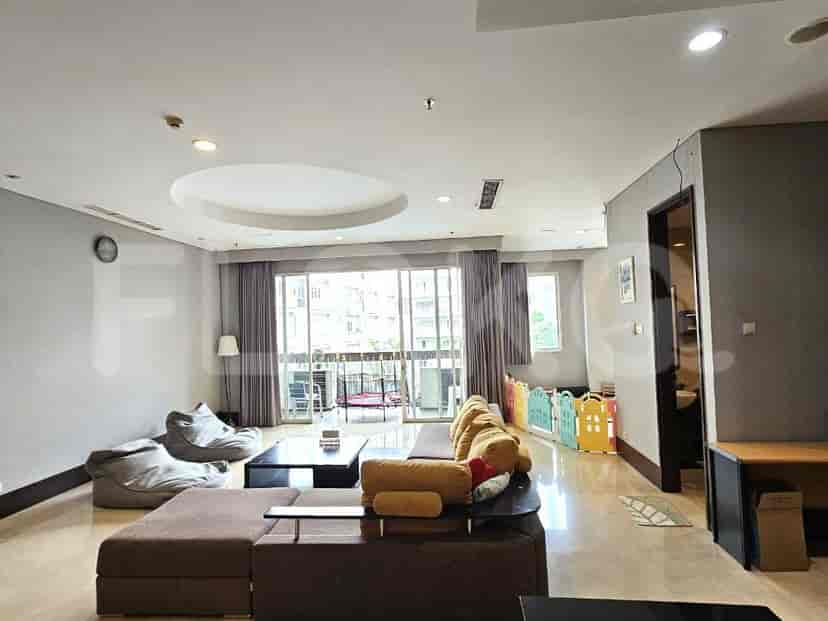 Spacious living room with large windows, multiple seating areas, and a play area.