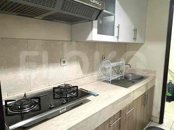 A compact kitchen with cabinets, stove, and sink.