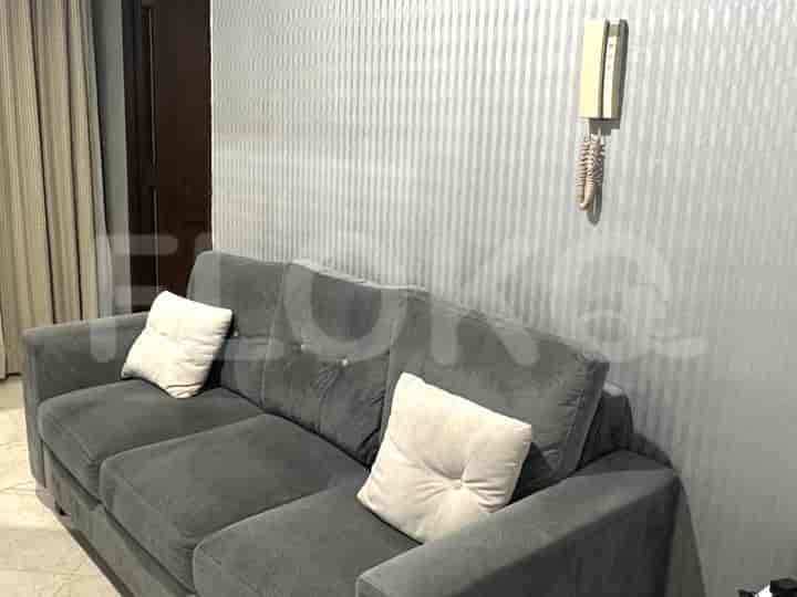 A well-lit living room featuring a grey sofa and patterned wallpaper.