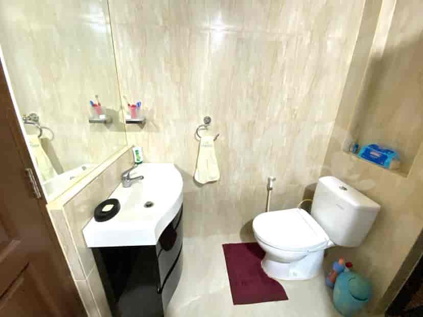 A bathroom with a toilet, sink, and mirror.