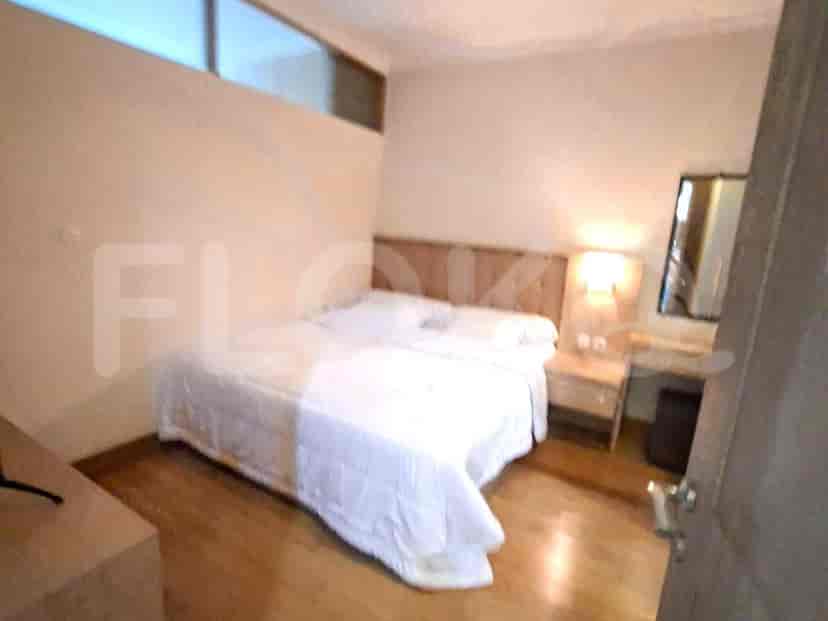 A simple bedroom with a double bed and nightstand.
