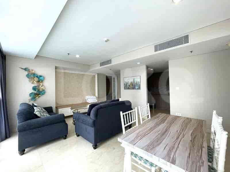 Living area with sofas, dining area, and wall decor.