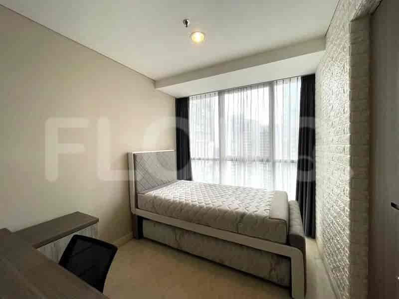 A small bedroom with a single bed and a desk.