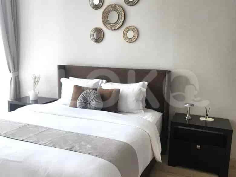 Double bed in a bedroom with decorative mirrors.