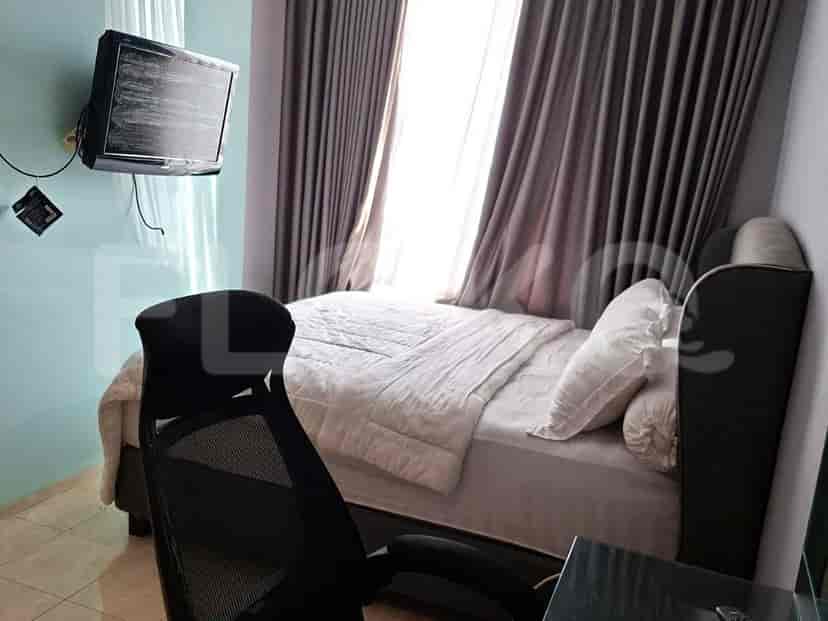 Kamar tidur dengan tempat tidur, meja, dan TV.