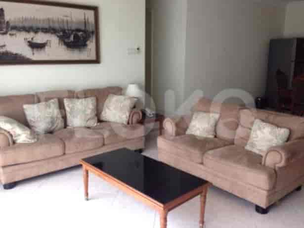 Living room with a brown sofa, black table, and a painting on the wall.