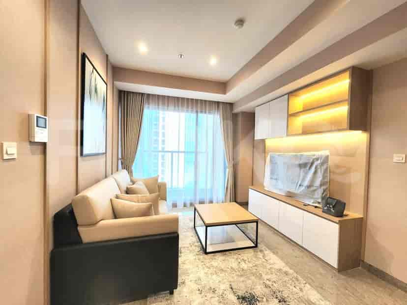 Ruang tamu modern dengan sofa sectional, unit hiburan, dan jendela besar.